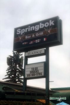 the sign for springbok bar and grill in front of a building with trees