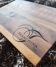 a wooden cutting board with the name franchinia on it sitting on a rug