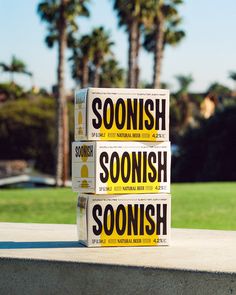 three books stacked on top of each other in front of some palm trees and grass