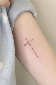 a person with a cross tattoo on their arm