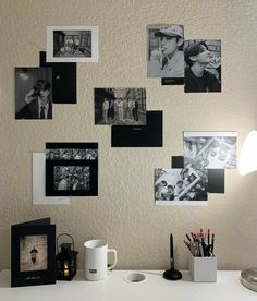 a white desk topped with lots of photos and pictures on the wall above it's head