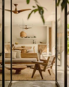 a living room filled with furniture and lots of glass doors leading to an outside patio