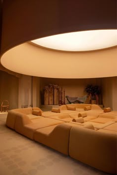 a large couch sitting in the middle of a living room under a round light fixture