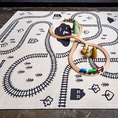 a toy train set sitting on top of a white rug with black and white designs