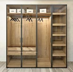 an empty walk in closet with wooden shelves and glass doors that are open to reveal the inside