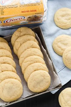 a box full of cookies sitting on top of a table next to a container of sugar