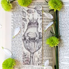 an open book with flowers on it and a frog drawn on the page next to it