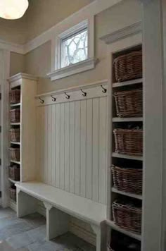 a white bench sitting in the middle of a room with baskets on it's back