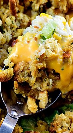 a close up of a spoon in a casserole dish with stuffing and vegetables