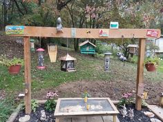 a bird feeder in the middle of a garden with lots of birds on top of it