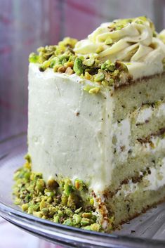 a piece of cake with white frosting and pistachio sprinkles