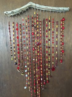 a bunch of beads hanging from a wooden wall