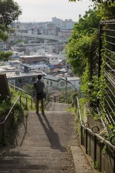 a person walking up some stairs with buildings in the background