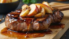 some meat and apples on a cutting board with sauce drizzled over it