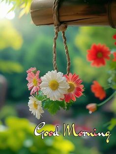 a bunch of flowers hanging from a wooden pole with the words good morning on it