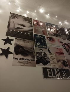 a bunch of movie posters hanging on the wall with lights in the room behind them