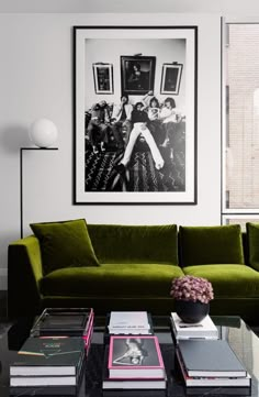 a living room with green couches and pictures on the wall above them in black and white