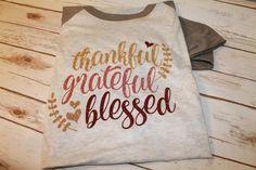 a t - shirt that says thank grateful and is on the floor next to a pair of jeans