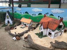 there are many small houses made out of wood logs and fake animals on the ground