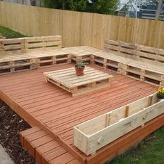 an outdoor seating area made out of pallets and wooden planks with potted planter on top