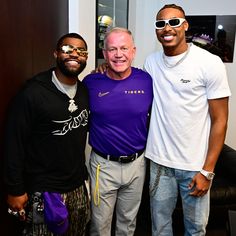 three men standing next to each other smiling