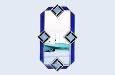 a mirror that is sitting on top of a blue tablecloth with an image of a surfboard in the reflection