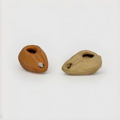 two small wooden objects on a white surface