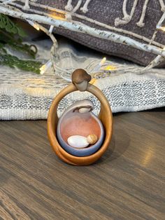 a small ceramic mushroom in a wooden ring on a table next to a christmas tree