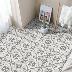 a white and gray patterned floor next to a potted plant on a stand in front of a window