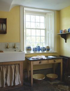 a kitchen with yellow walls and white trim on the window sill, sink and counter