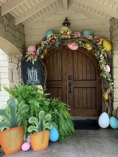 an entrance to a home decorated with easter eggs and plants in front of the door