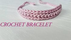 a pink crochet bracelet on top of a white table with the words crochet bracelet written across it