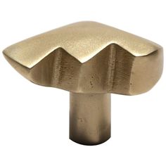 a brass knob with an arrow shaped design on the front and back end, set against a white background