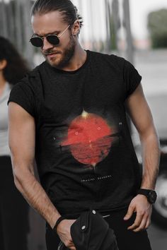 a man wearing sunglasses and a black t - shirt with a red heart on it