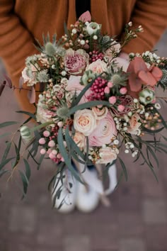 a woman holding a bouquet of flowers in her hands