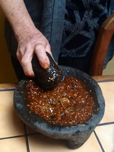 a person is dipping something into a bowl