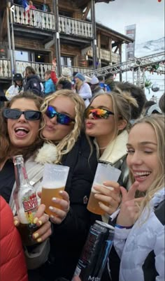 a group of women standing next to each other holding beers