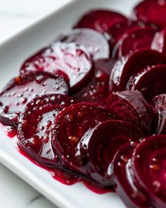 sliced beets on a white plate with red sauce