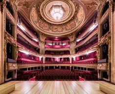 an empty theatre with red seats and wooden floors