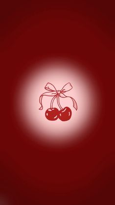 two cherries are tied with a bow on a red background that is lit up