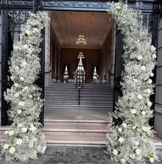 an entrance to a building decorated with white flowers