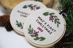 two cross stitch christmas ornaments with pine cones