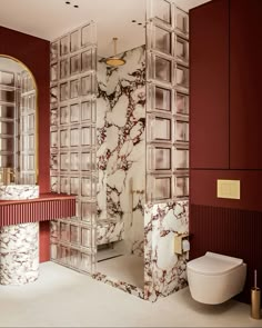 a bathroom with red walls and white marble counter tops, toilet and sink in the middle