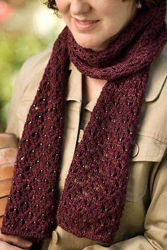 a woman wearing a knitted burgundy scarf