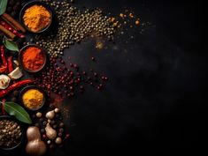 spices and herbs arranged in bowls on a black background