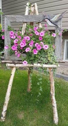 an old wooden chair with flowers growing out of it's back legs in front of a house