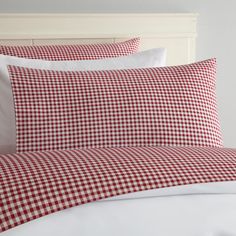 a red and white checkered comforter set on a bed