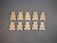 six wooden teddy bears arranged in rows on a gray surface