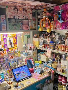 a room filled with lots of toys and other items on shelves next to a laptop computer