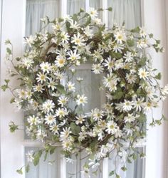 a wreath with daisies is hanging on the front door